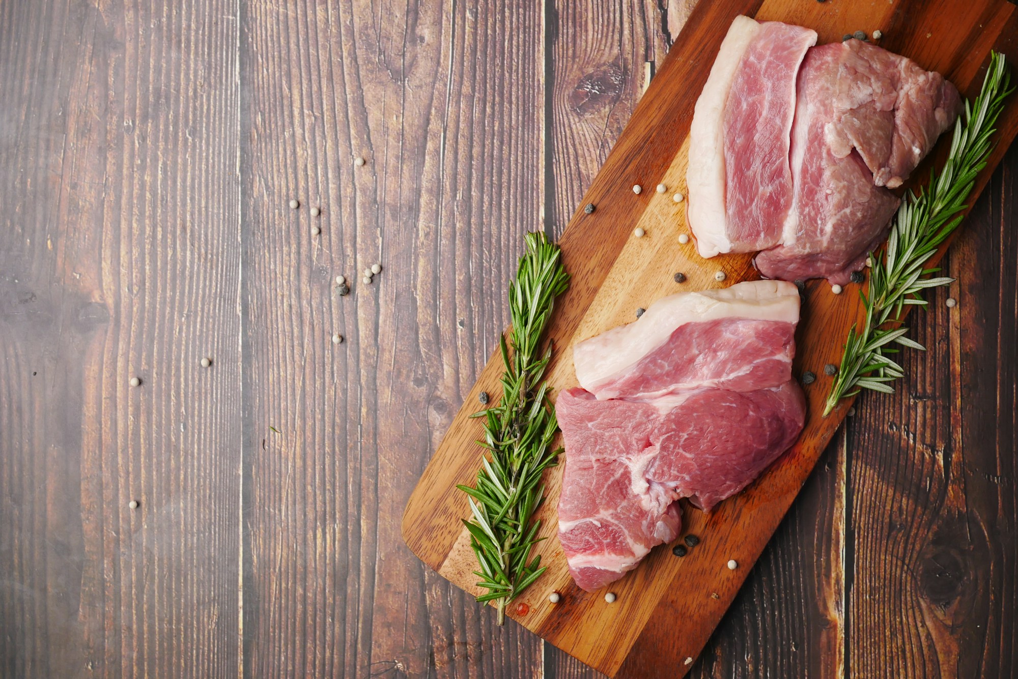 Illustrative stock image: fresh raw pork cuts on a board